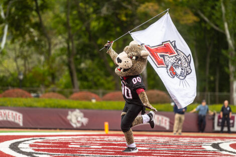 Laf Leopard running across Fisher Stadium with flag.